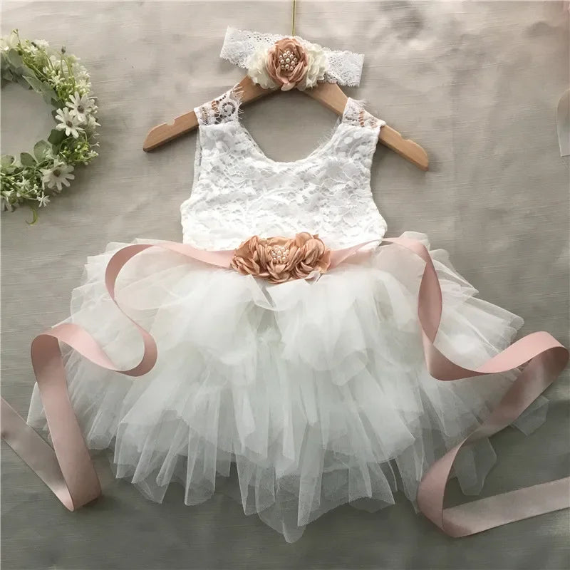 Elegant Roxane vintage-inspired girls beaded dress set in white lace with tulle skirt, pink belt and headband.