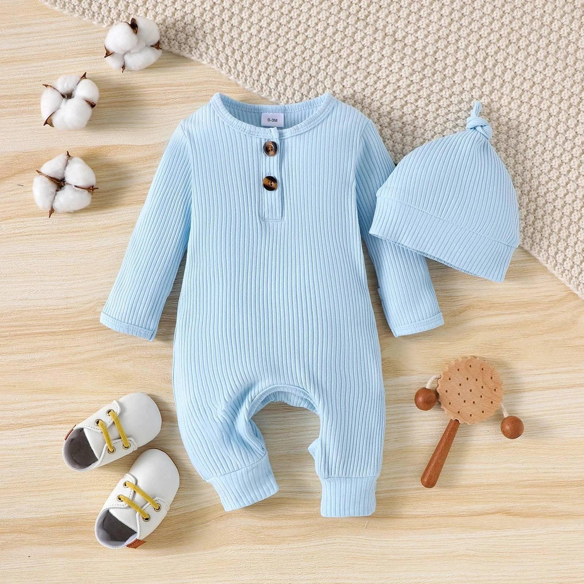 baby blue ribbed romper with matching hat for 0-6 months laid flat with baby shoes and wooden toy