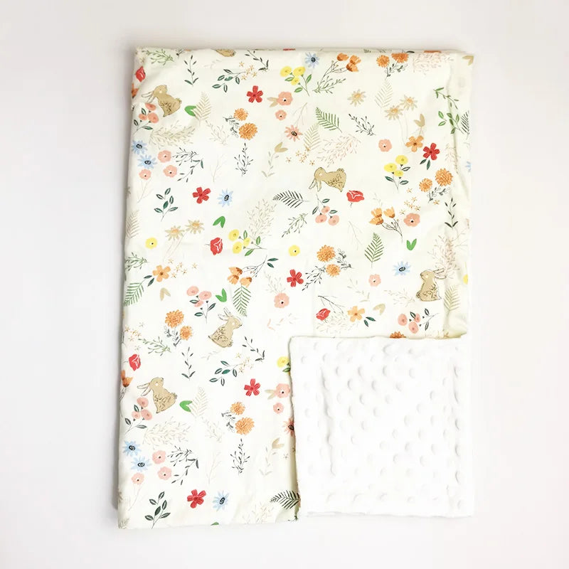 Soft baby minky blanket featuring playful bunny and floral print with white dot texture backing, ideal for infants and toddlers.