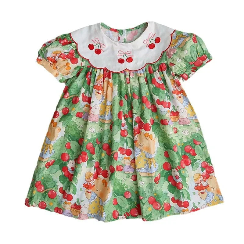 Front view of A Very Cherry Day Embroidered Dress laid flat, showcasing the adorable cherry print dress with its crisp colors and fun motifs.