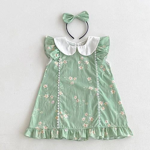 Vintage Outfits for girls displaying a green dress with delicate floral details and a coordinating headband from The Palm Beach Baby.