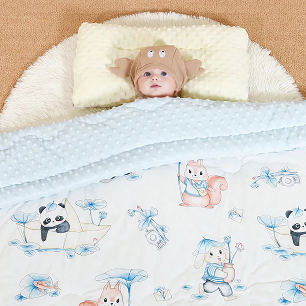 Baby on a quilted 120 x 150 cm nap blanket with raised dots and panda, whale, bear, elephant, rabbit prints.
