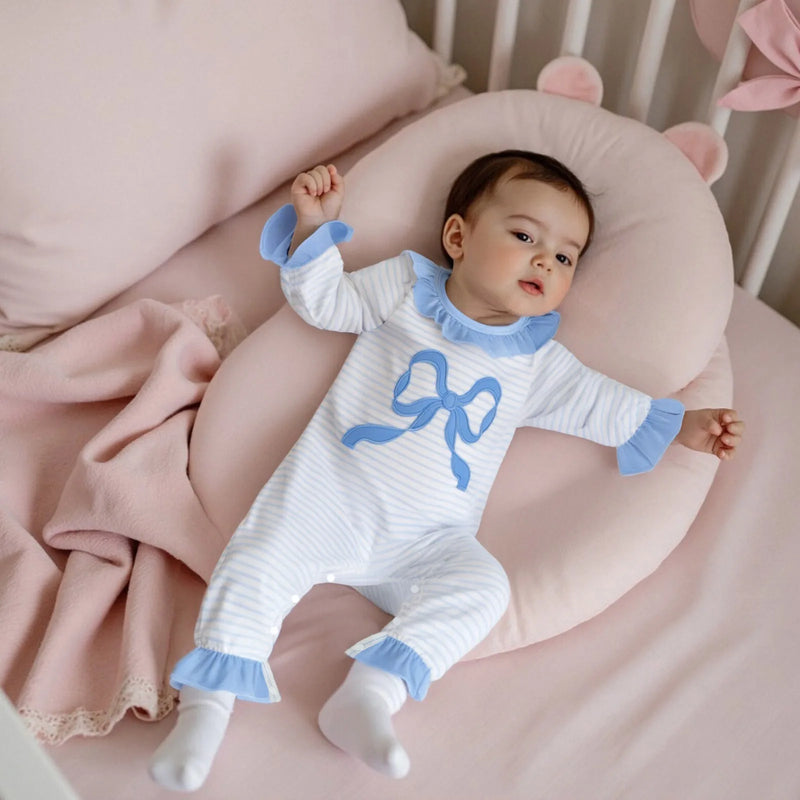 Infant resting in the Little Bow Peep adorable long sleeve baby romper, highlighting its soft fabric and gentle design for comfort.