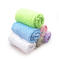 Stack of soft baby fleece blankets in lime green, blue, white, beige, pink and purple, 100x70 cm swaddle set.