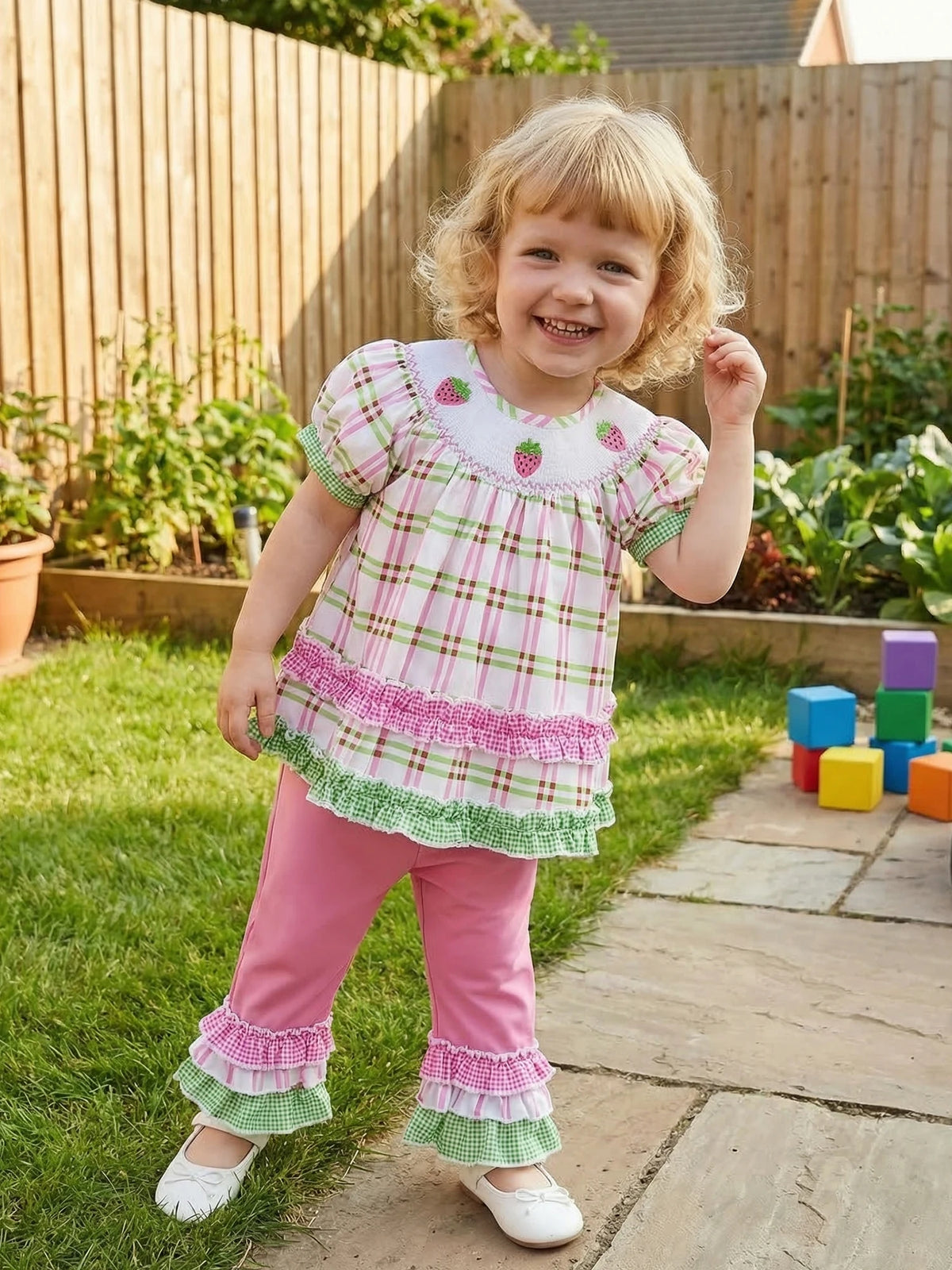 Little girl wearing Frilly Boho Plaid Embroidered two-piece set with puff sleeves and frilled trim, outdoors