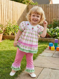 Little girl wearing Frilly Boho Plaid Embroidered two-piece set with puff sleeves and frilled trim, outdoors