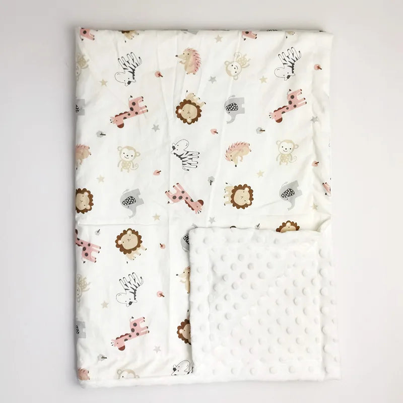Soft minky baby blanket featuring cute lion, giraffe, and zebra prints on one side with plush white dotted texture on the reverse.