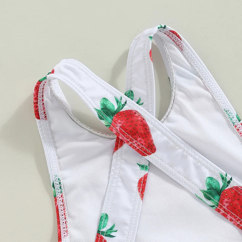 White strawberry-print toddler one-piece swimsuit with crisscross back straps.