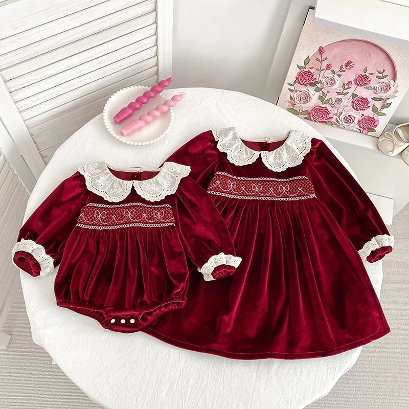 Deck the Halls Smocked Velvet and Frills Sibling Outfits - Deep Red featuring a beautiful dress and matching romper adorned with lace collars and smocking details.