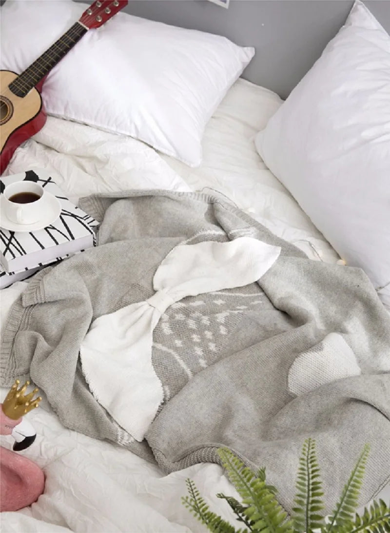 A colorful view of a playful unicorn blanket draped on a bed, showcasing designs from the 'Sleepy Tight' cute animal blankets.