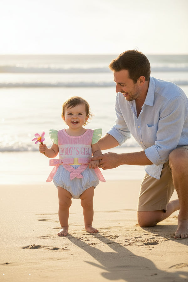Embroidered Daddy's Girl bubble romper with pink bodice, green ruffle sleeves, blue seersucker bloomers and pink bows.