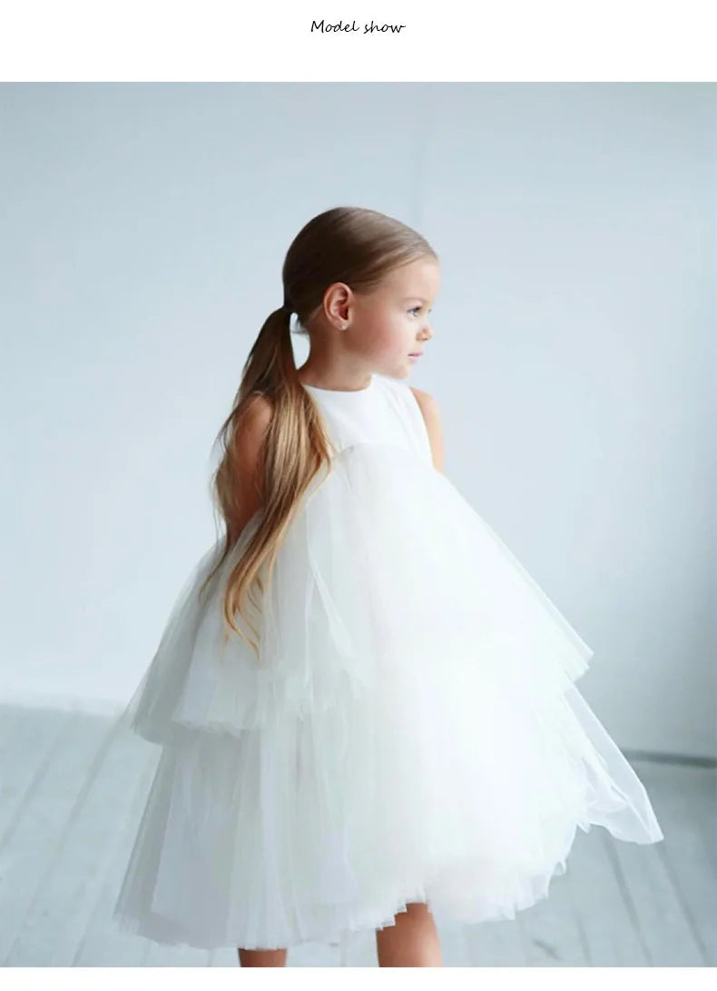 White Cara Ann girls tiered tulle party dress with empire waist and round neckline, mid-calf length.