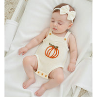 Sleeveless knit romper overalls with pumpkin applique and bow headband for babies. Breathable acrylic fabric with festive embroidered detail.