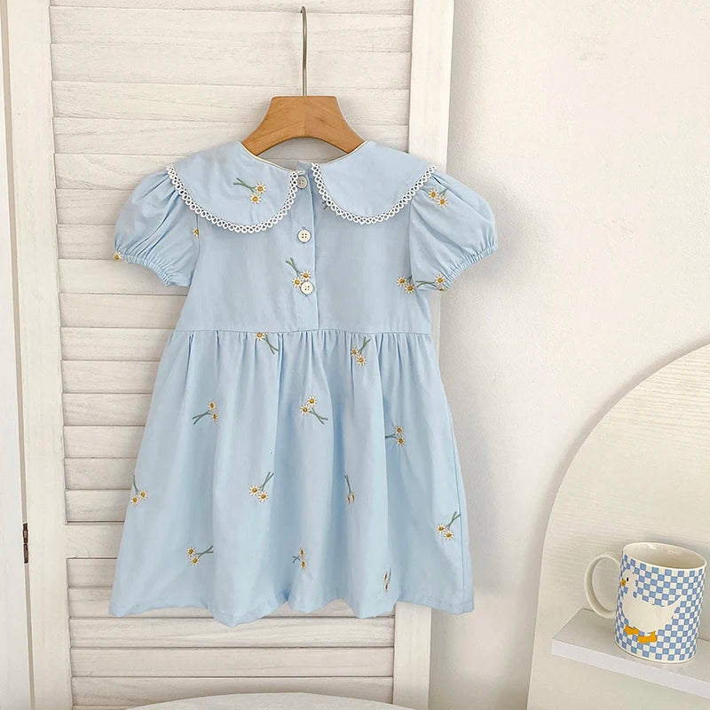 Sweet Lydia Little Girl's Dress in pastel blue featuring a charming collar and embroidered daisies, designed for little girls aged 2 to 6 for fun and comfort.
