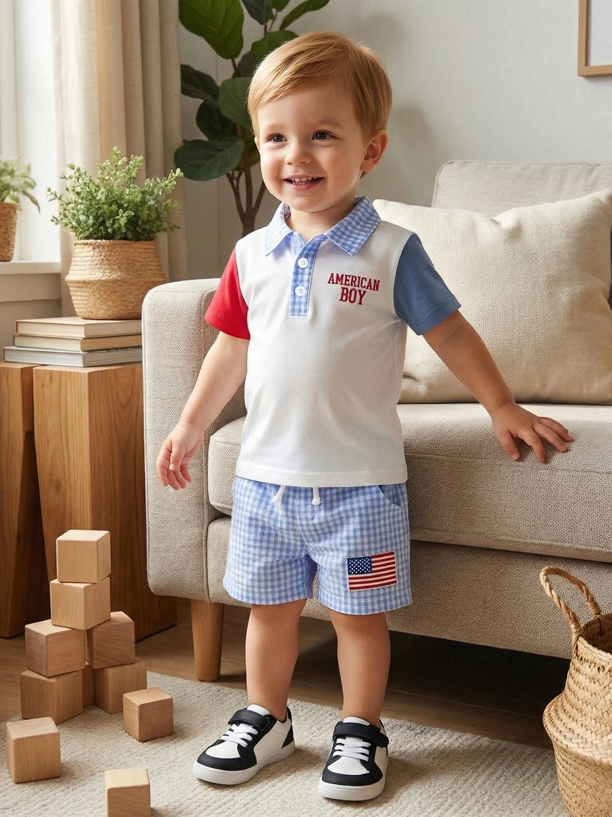 Toddler in patriotic outfit: white polo with red and blue sleeves, blue check seersucker shorts with American flag patch