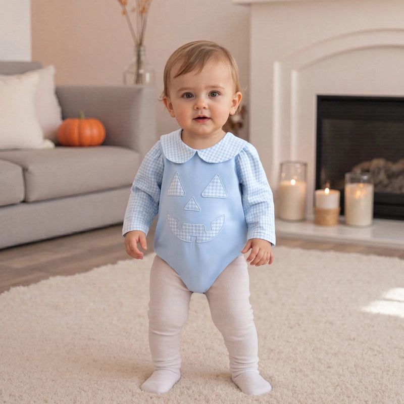 Cute child in the "Peter Pumpkin" Adorable Baby Blue Romper with Snaps, captured in a cozy room with festive decorations.