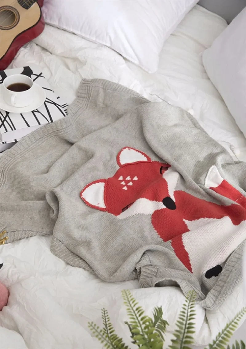 A cozy gray fox blanket nestled on a bed, part of the 'Sleepy Tight' cute animal blankets collection.
