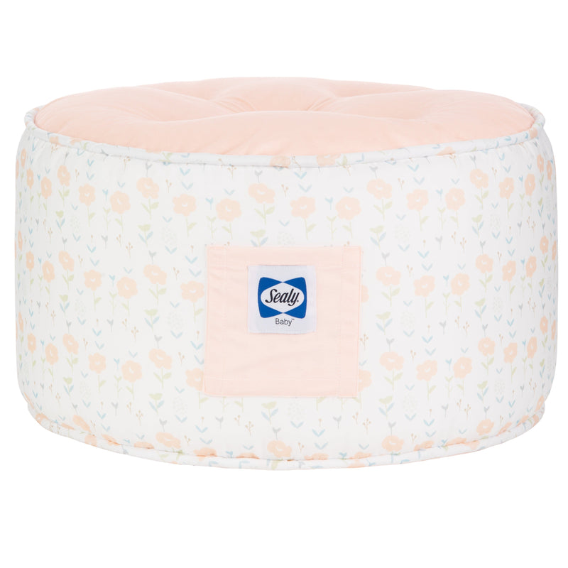 Sealy Pouf - Coral & Blossoms, featuring a cozy round design with a soft pink top and floral pattern, perfect for toddlers' playroom or nursery.