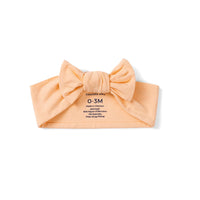Reverse side of peach bamboo rayon infant band showing 0-3M size and material composition details