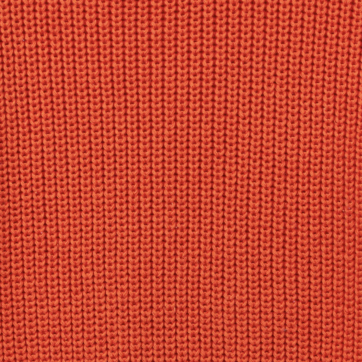 Vibrant orange rust knit fabric close-up highlighting vertical ribbed stitch pattern and soft cotton texture
