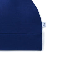 Side view of navy blue hat showing folded hem and swan logo tag