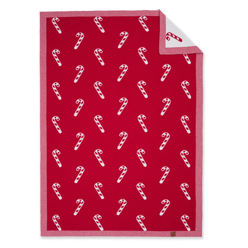 Red and white candy cane jacquard baby blanket flat lay with folded corner showing reverse side
