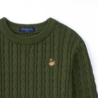 High-angle close-up of inner neck label reading SWaddle AN 18-24M next to gold swan emblem on knit texture