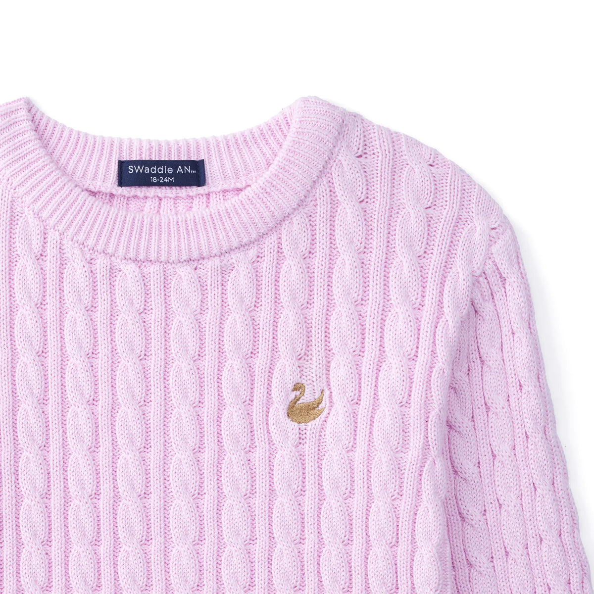 High-angle view of ribbed crew neck stitching, back collar tag, and gold swan emblem on textured knit