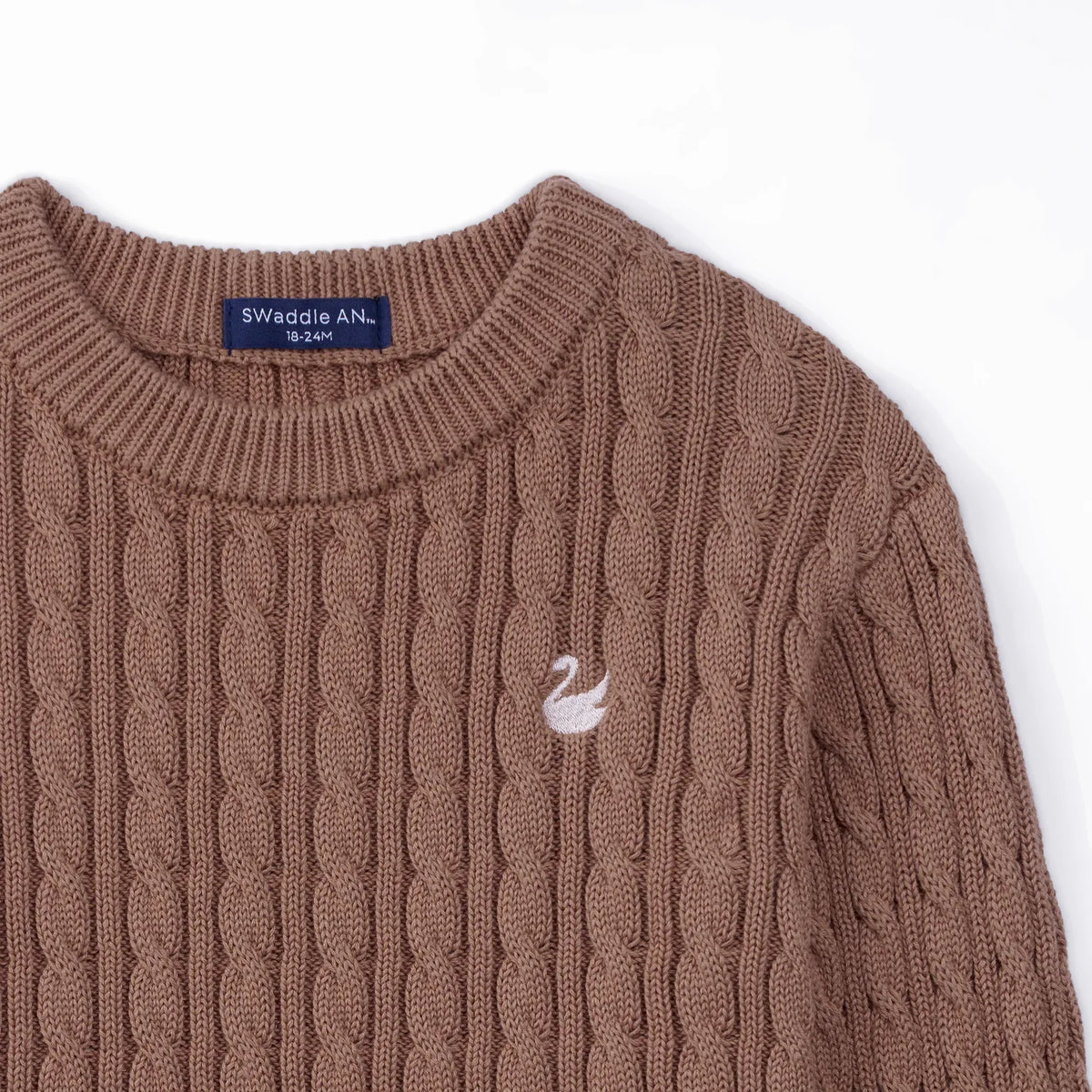 High-angle view of mocha sweater shoulder area showing inner size label and embroidered swan logo