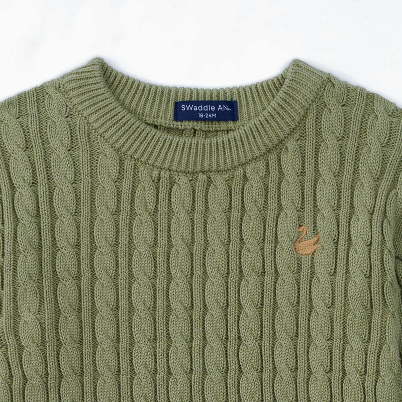 Close-up of sage green cable knit texture and navy SWaddle AN size tag on neckline