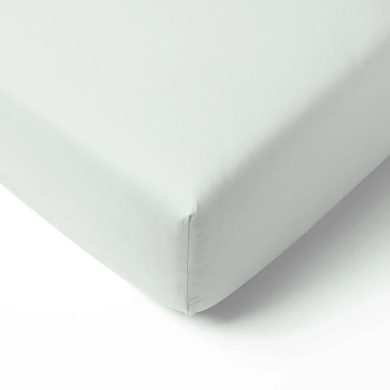 Mint green bamboo crib sheet fitted tightly on a mattress corner, showing smooth fabric texture and precise elastic stitching