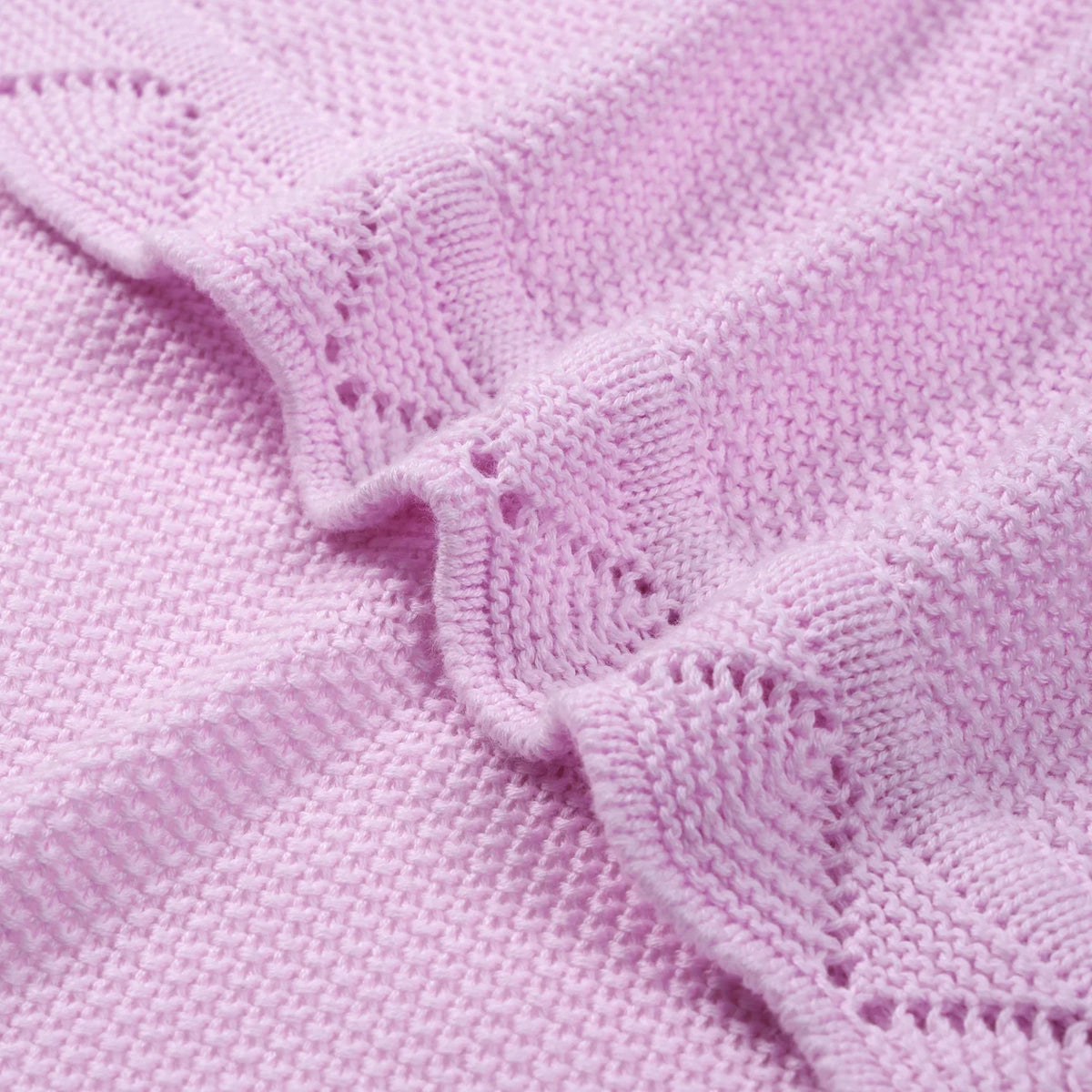 Close-up of intricate lace border detail on soft lilac cotton yarn texture