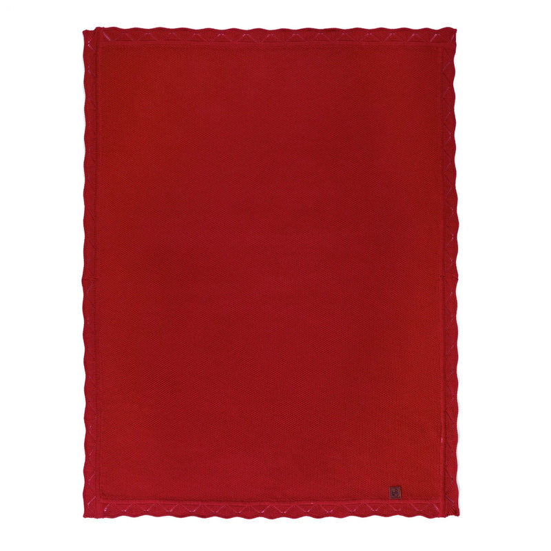 Unfolded red garter stitch blanket showing rectangular shape, lace edging, and corner tag
