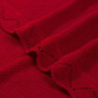 Close-up of red cotton fabric texture and delicate openwork lace pattern along scalloped border