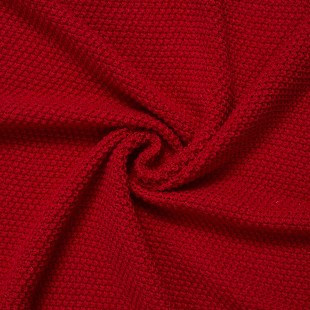 Spiral swirl of red knit textile demonstrating drape, flexibility, and uniform stitch detail