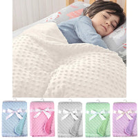 Sleeping baby under a white dotted fleece blanket; 100x70 cm unisex swaddle set, solid colors, soft warm polyester.
