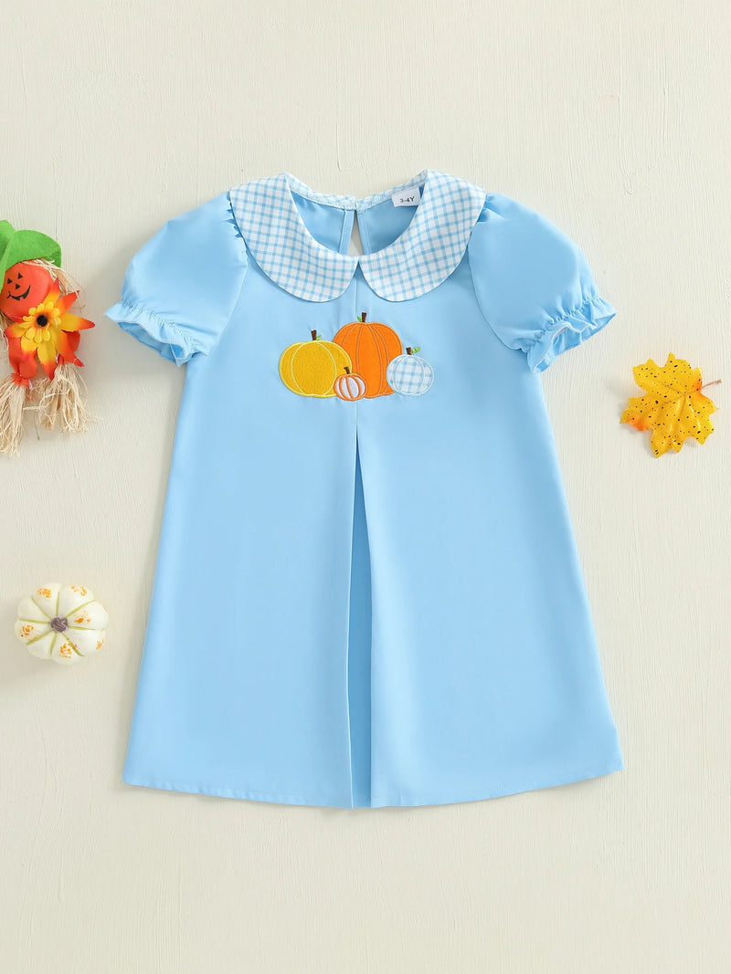 Styled image of the Pretty in Pumpkin Girls Embroidered Fall Dress - Newport Blue against a festive backdrop, highlighting its charming embroidered pumpkins and seasonal design.