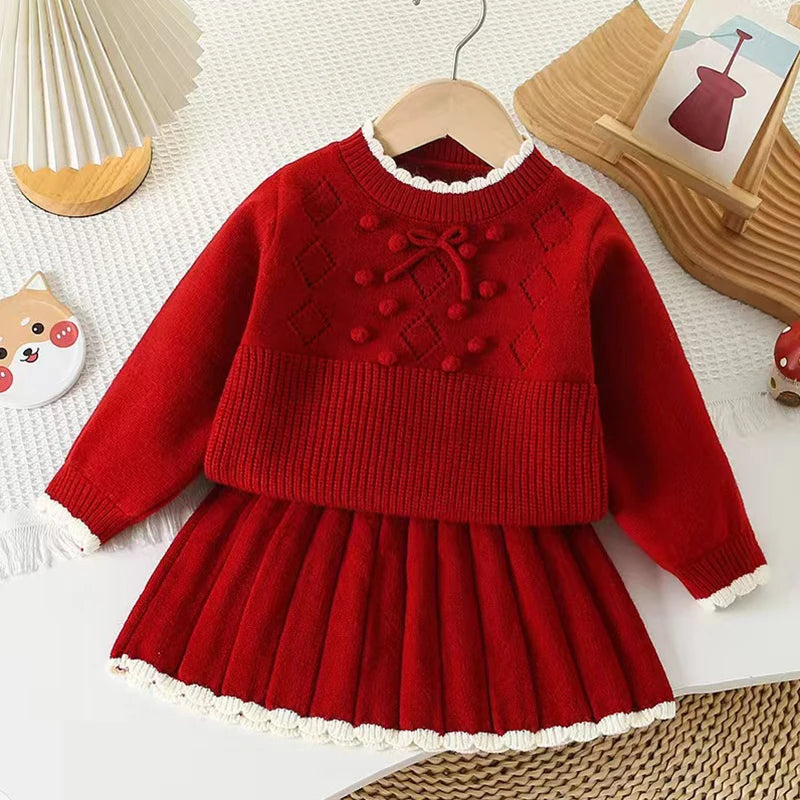 Adorable Anna Knit Skirt Set for Girls featuring a cozy red pullover top and accordion-pleated skirt, perfect for chilly days.