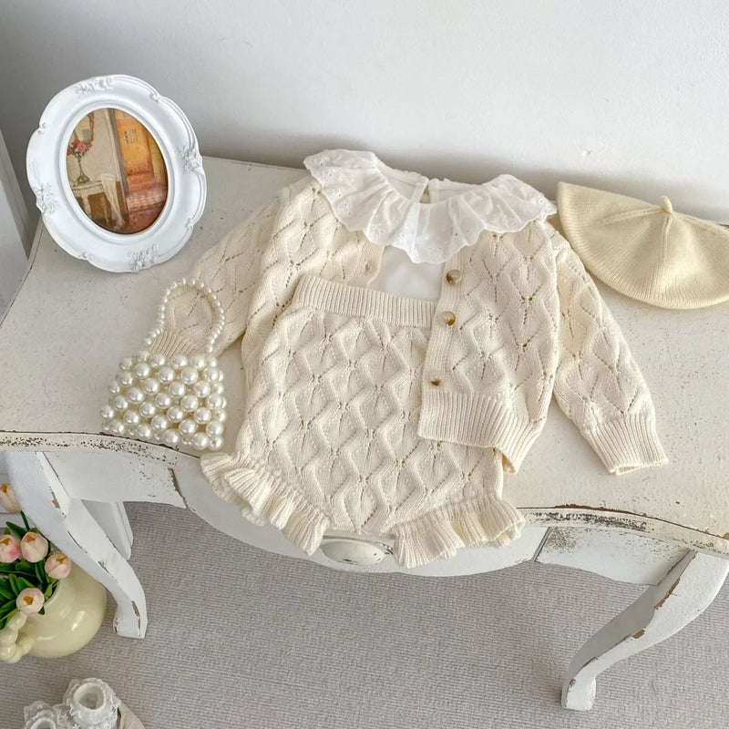 Flat lay of the Margaret-Ann Knitted Girls Sweater Suit featuring a buttoned cardigan and knitted bloomers, complemented by a stylish collar and accessories.