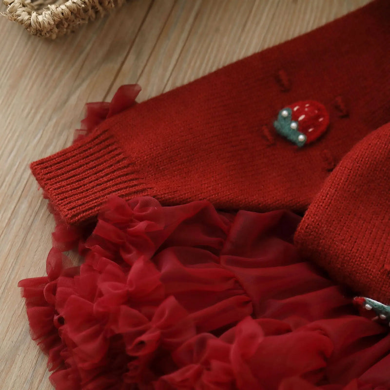 The sleeve and ruffled hem detail of the knit sweater and tulle skirt set, highlighting the charming design of the Strawberry Girls Knit Sweater and Tulle Skirt - Deep Red.