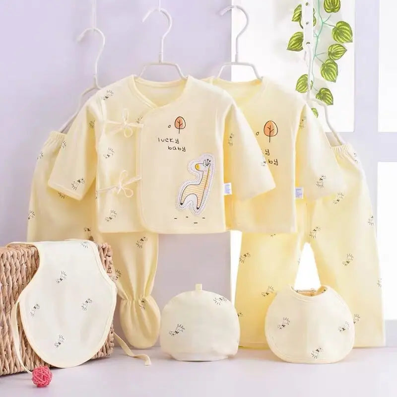 Playful giraffe-themed 7-piece newborn layette set in sunshine-yellow cotton with hats, bibs, and footed/unfooted pants.