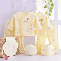 Playful giraffe-themed 7-piece newborn layette set in sunshine-yellow cotton with hats, bibs, and footed/unfooted pants.