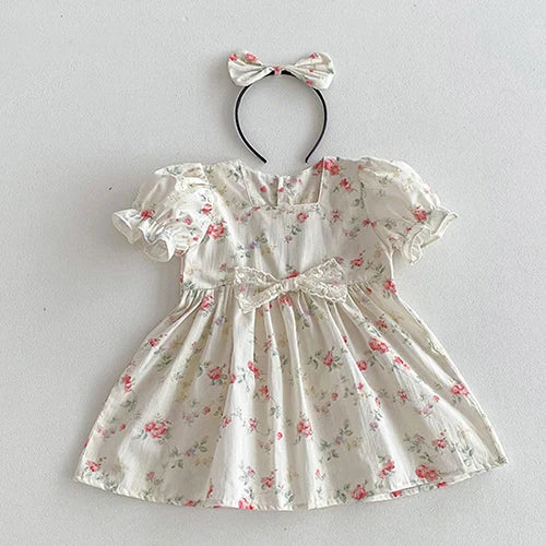 Vintage Outfits from The Palm Beach Baby, showcasing a lovely floral dress with a bow and a matching headband.