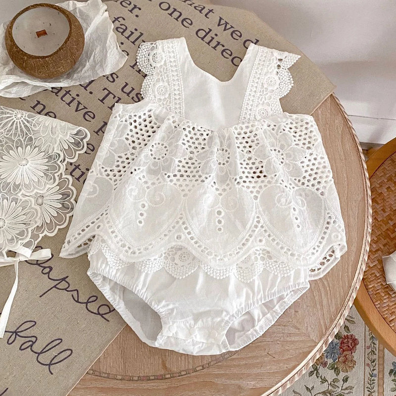 Adorable "Summer Sweet" Lace Baby's Romper displayed on a wooden table, featuring elegant white eyelet lace and a comfy pullover design for summer adventures.