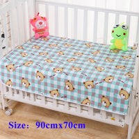 Childrens waterproof changing pad with cute bear-print blue-check pattern on crib, 90x70 cm.