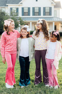 Four girls model a pink star print sweater, velvet flares, and daisy top.Perfect cozyKids winter wear.