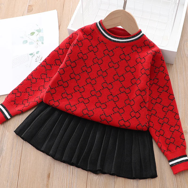 The "Morgan" Classic Knit Skirt Set in red with a black pleated skirt, designed for comfort and style for young girls.