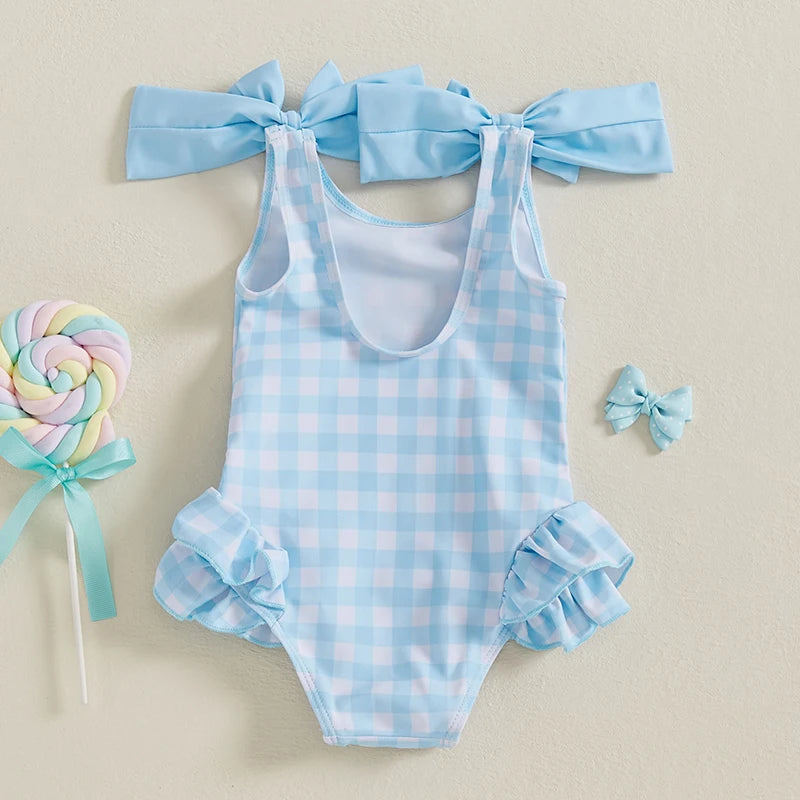 Cute In Checks cute swimsuit for kids in blue check pattern, showcasing adorable ruffle accents and bows.