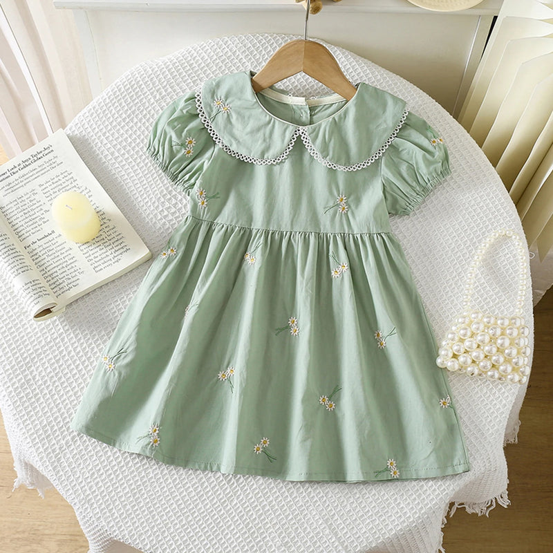 Sweet Lydia Little Girl's Dress in a soft green color featuring detailed embroidered daisies and a classic Peter Pan collar, perfect for ages 2 to 6.