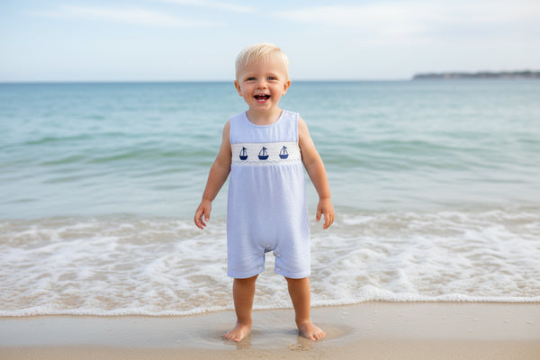 Light blue striped baby romper with sailboat design on a beige background